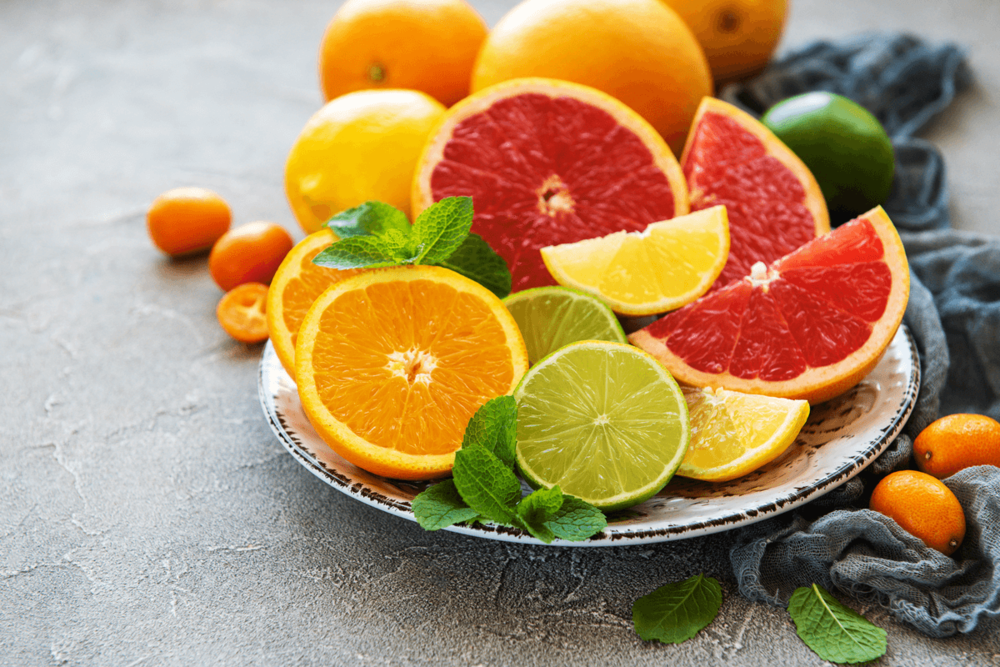 Sliced ​​citrus fruits on a plate: oranges, limes, lemons, blood oranges.